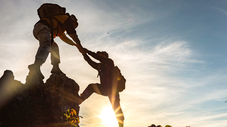 Male hikers helping each other