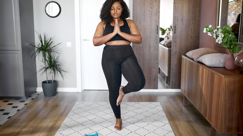 woman balancing on yoga mat