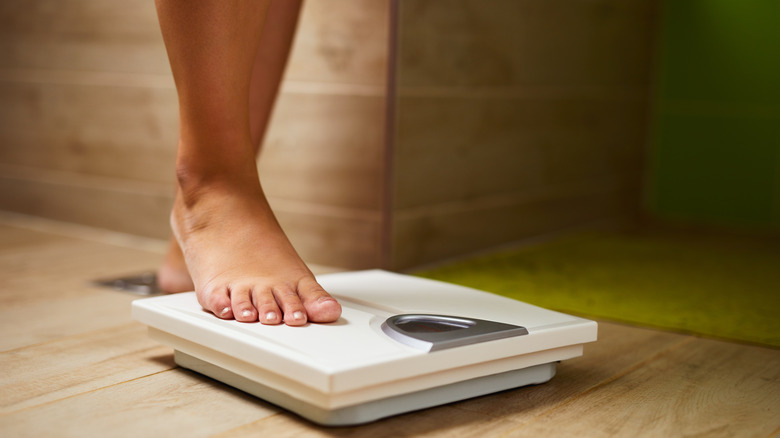 woman's feet stepping on scale