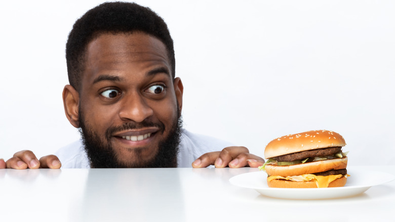 Hungry man looking at cheeseburger