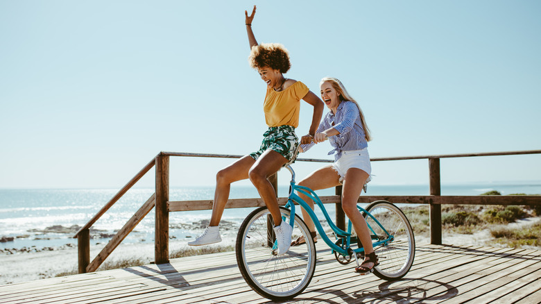 girls riding a bike on beach