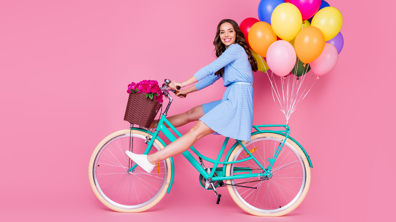 happy girl with balloons on a bike