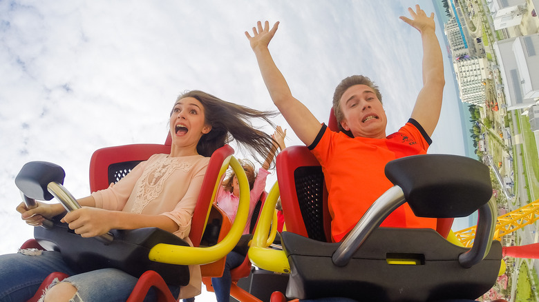 a young man and woman showing fear on a roller coaster