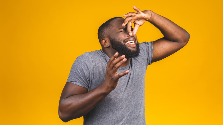 man pinching nose