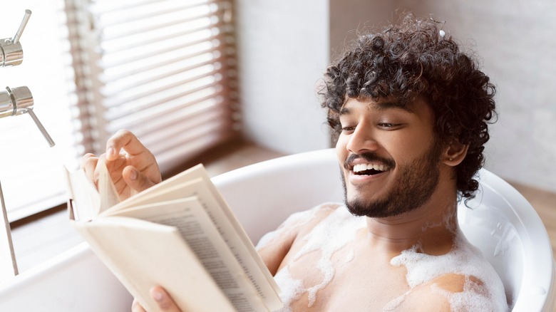 Man reading in bathtub