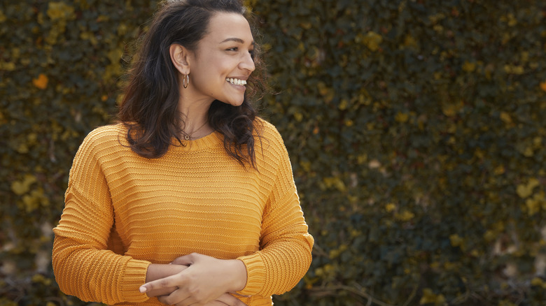 Smiling woman holding stomach