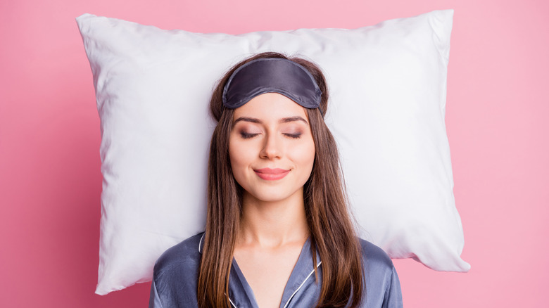 woman smiling with head on pillow
