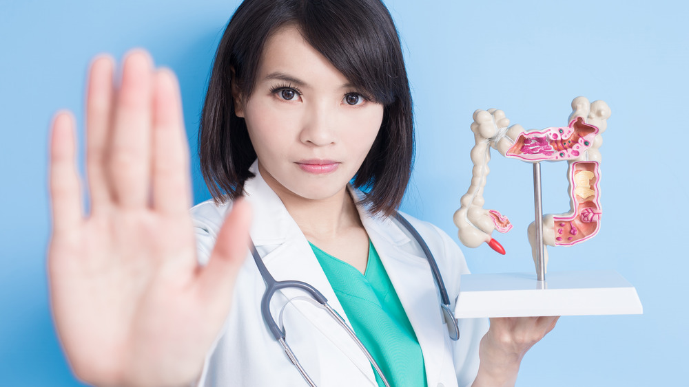 doctor holding model of colon