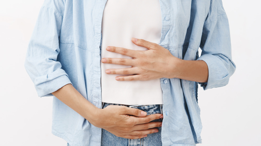 smiling woman holding stomach