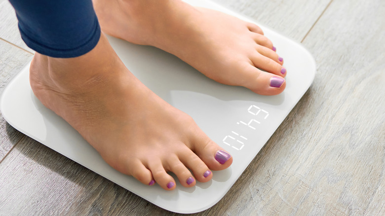 womans feet standing on weight scale