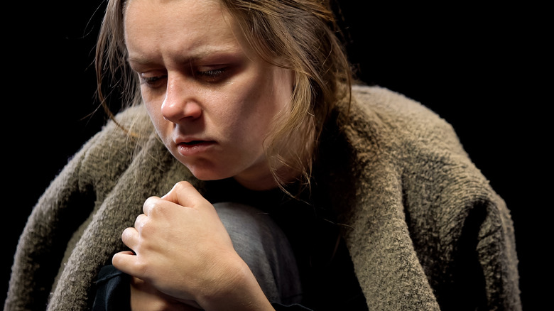 Young woman holding her shoulder