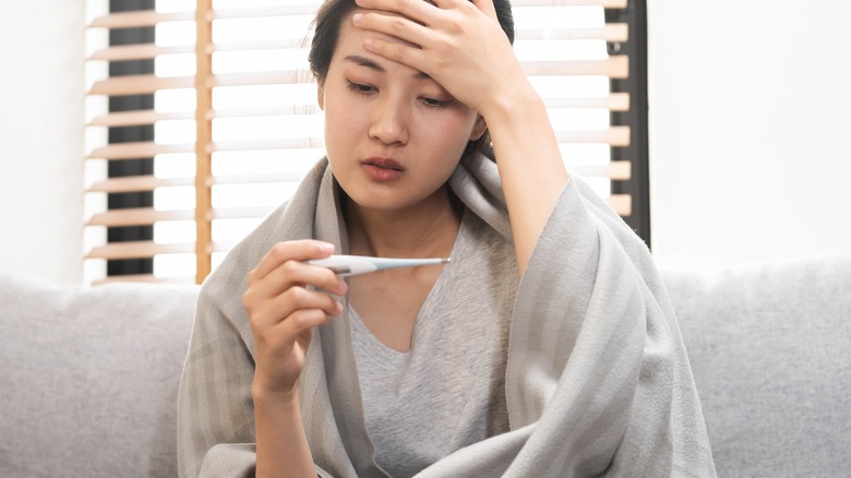 sick young woman sitting on couch