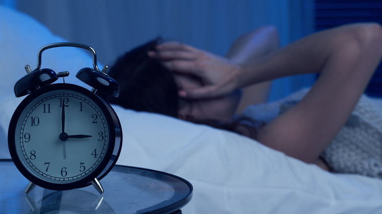 insomniac woman lying in bed at night