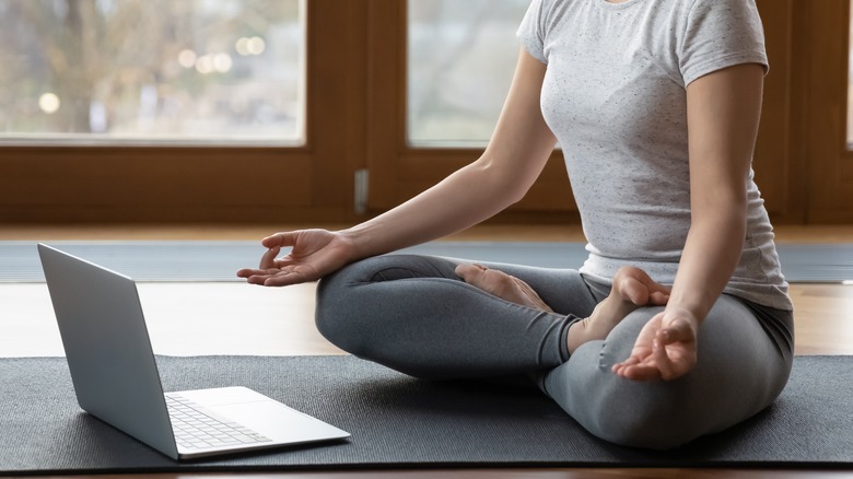A woman wearing leggings meditates