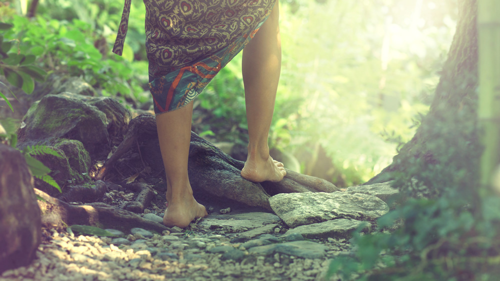 Person walking barefoot in woods