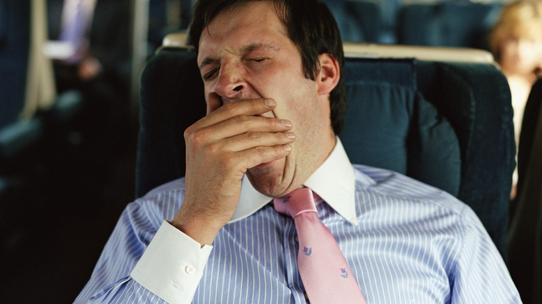 Man wearing a tie and yawning