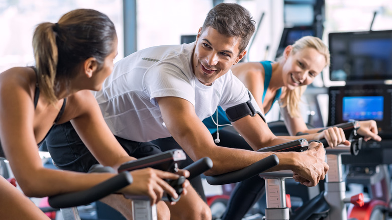 a man smiling while talking with a woman during spin class