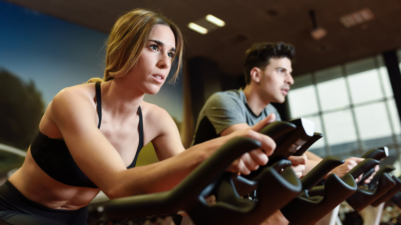 Woman and man working out on stationary bikes