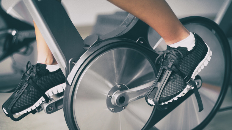 close up of a person's lower legs and feet on a spin class bike