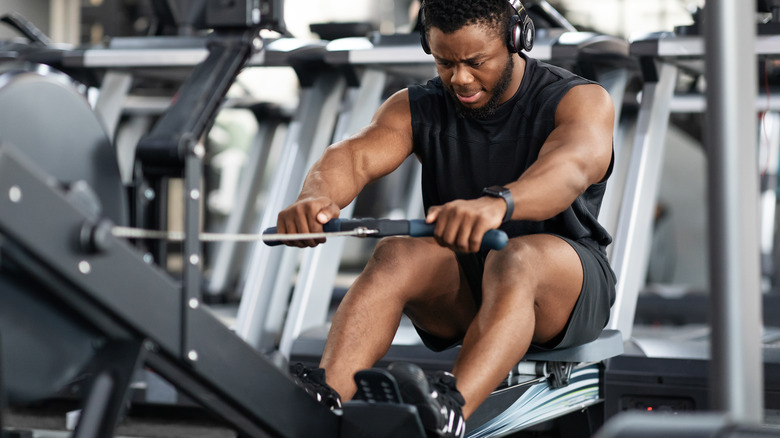 Man exercising on gym rowing machine