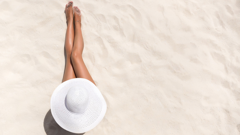 vacation concept. Overview image of a woman with tan legs on the beach 