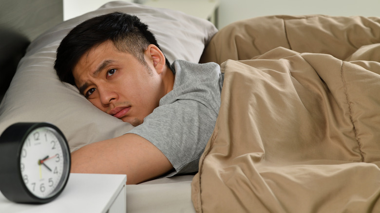 man in bed awake with eyes open