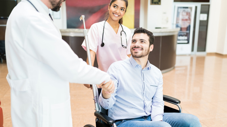 Man in wheelchair shaking doctor's hand