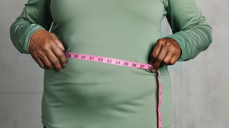 Woman measuring her waist