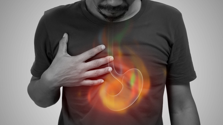 Man with holographic burning stomach from indigestion