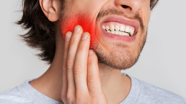 Man in pain touching his jaw