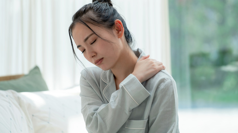 Woman holding her shoulder in pain