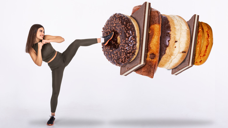 athletic woman kicking donuts