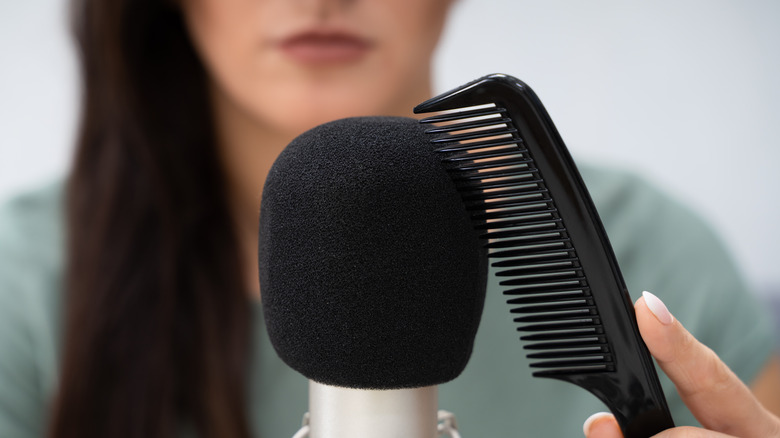 Woman brushing comb on microphone