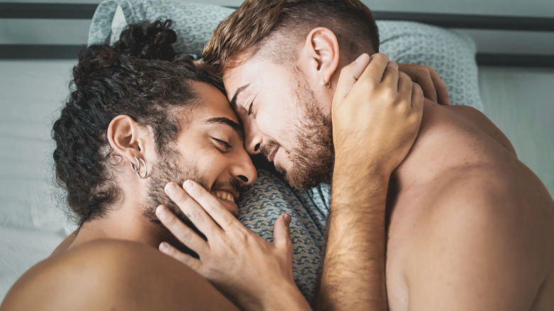 Couple smiling in bed after sex