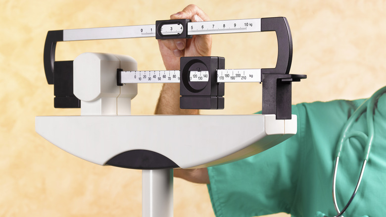 man's hand calibrating scale