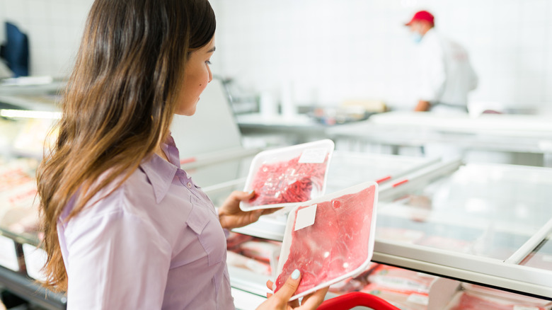 young woman buying red meat