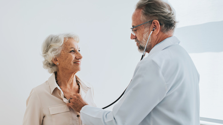 doctor checks woman's heart