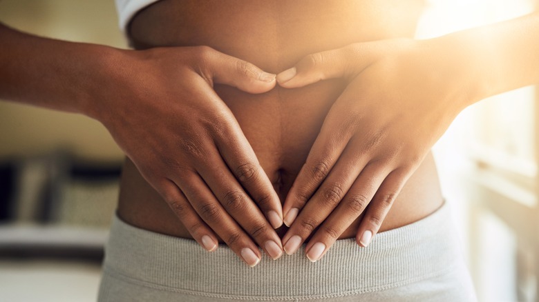 woman with hands on stomach