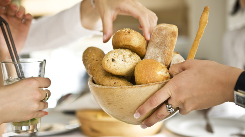 people passing bread bowl at dinner