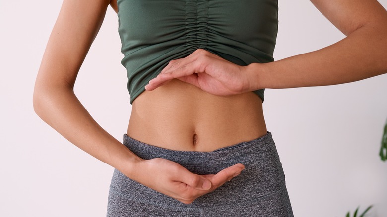 Woman with hands circling gut