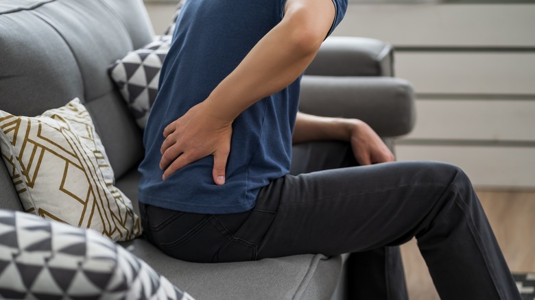 man grabbing painful lower back