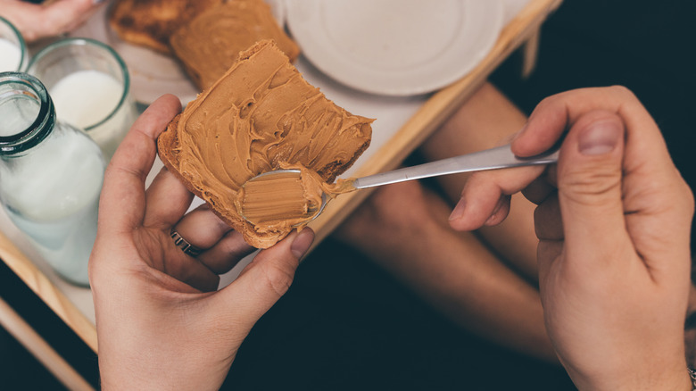 Man spreading peanut butter on bread