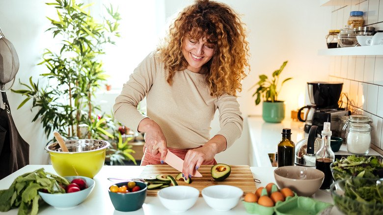 woman slicing avocado in her kitchen