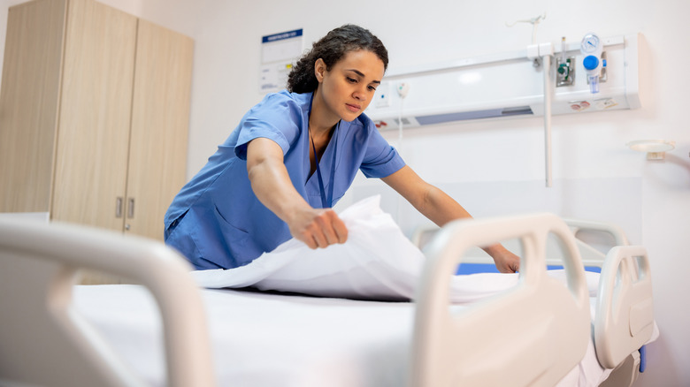 Nurse making up hospital bed