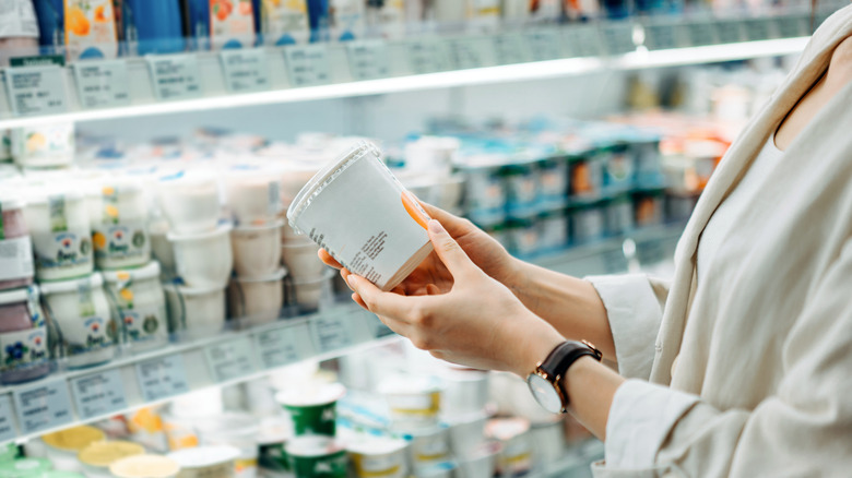 A woman's hands looking at a yogurt label