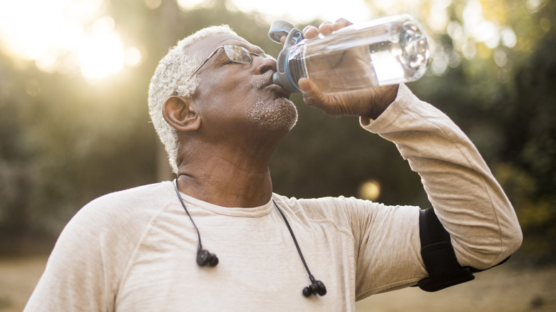 Exercising man drinking water bottle