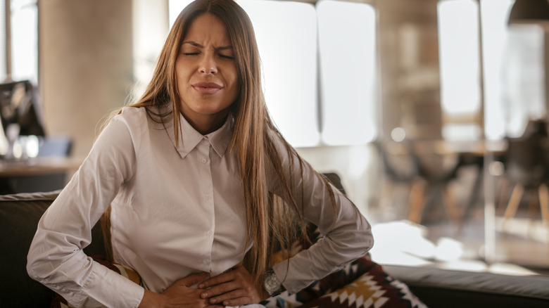 Woman wincing from stomach pain