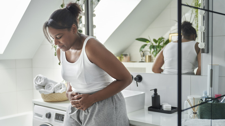 Woman with poop troubles holding abdomen