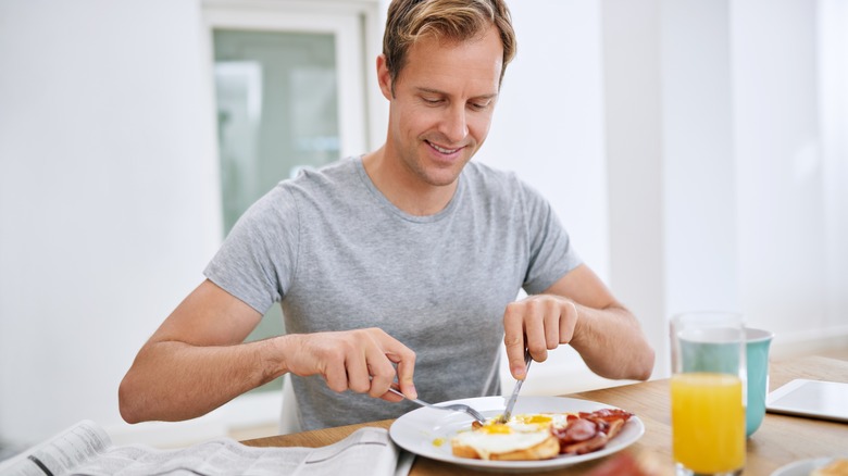 man eating eggs at breakfast