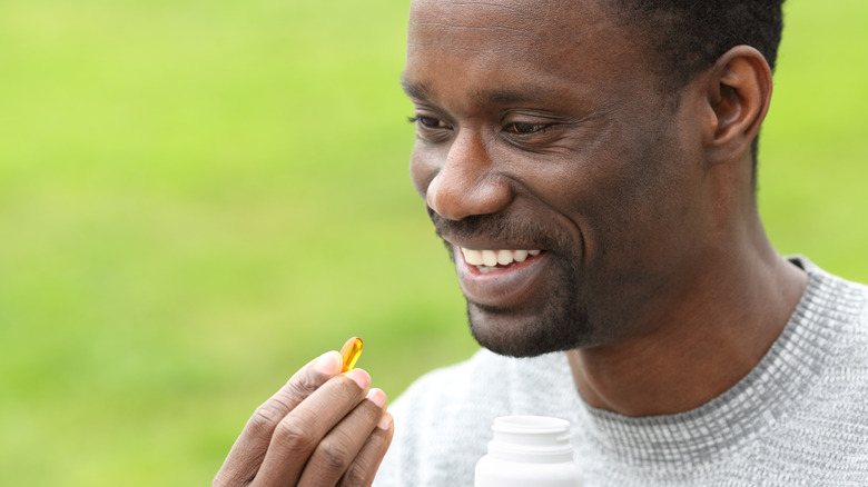 man taking a fish oil supplement